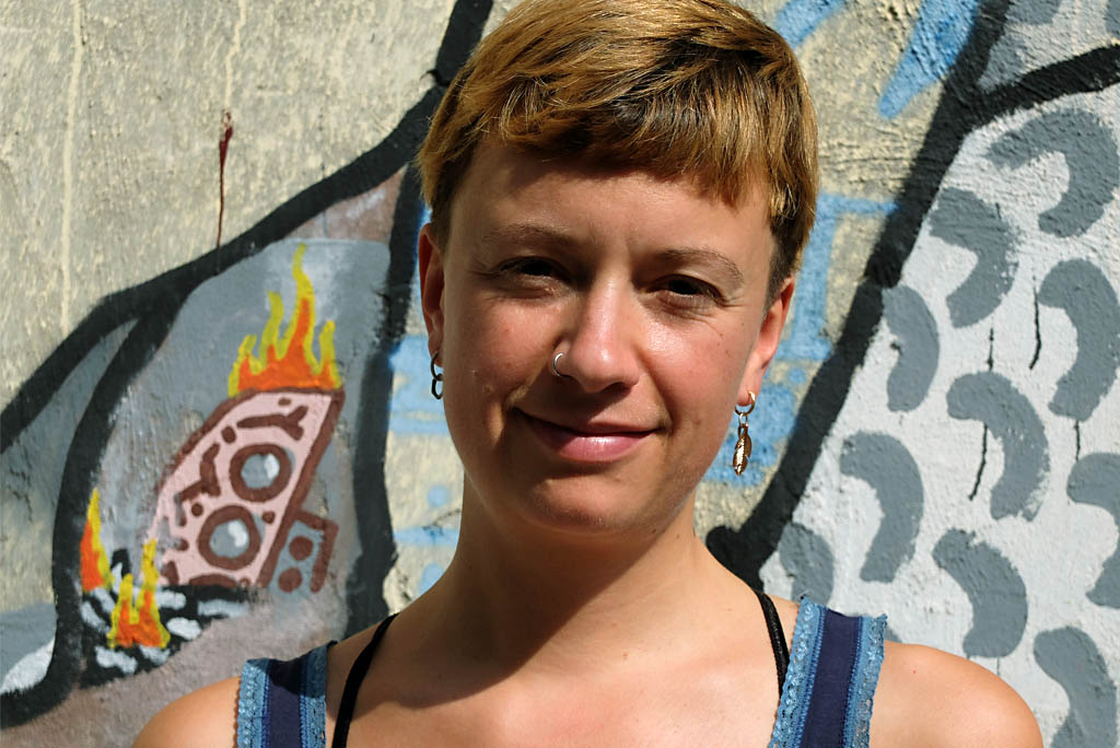 Portraitfoto einer jungen Frau mit kurzen goldbraunen Haare. Sie lächelt in die Kamera.