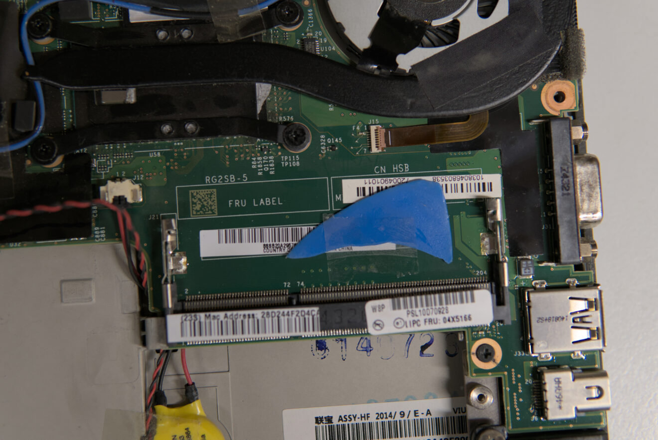 Das Innere eines Laptops ist zu sehen. Ein Stück blaues Plastik ist direkt auf den Arbeitsspeicher geklebt.