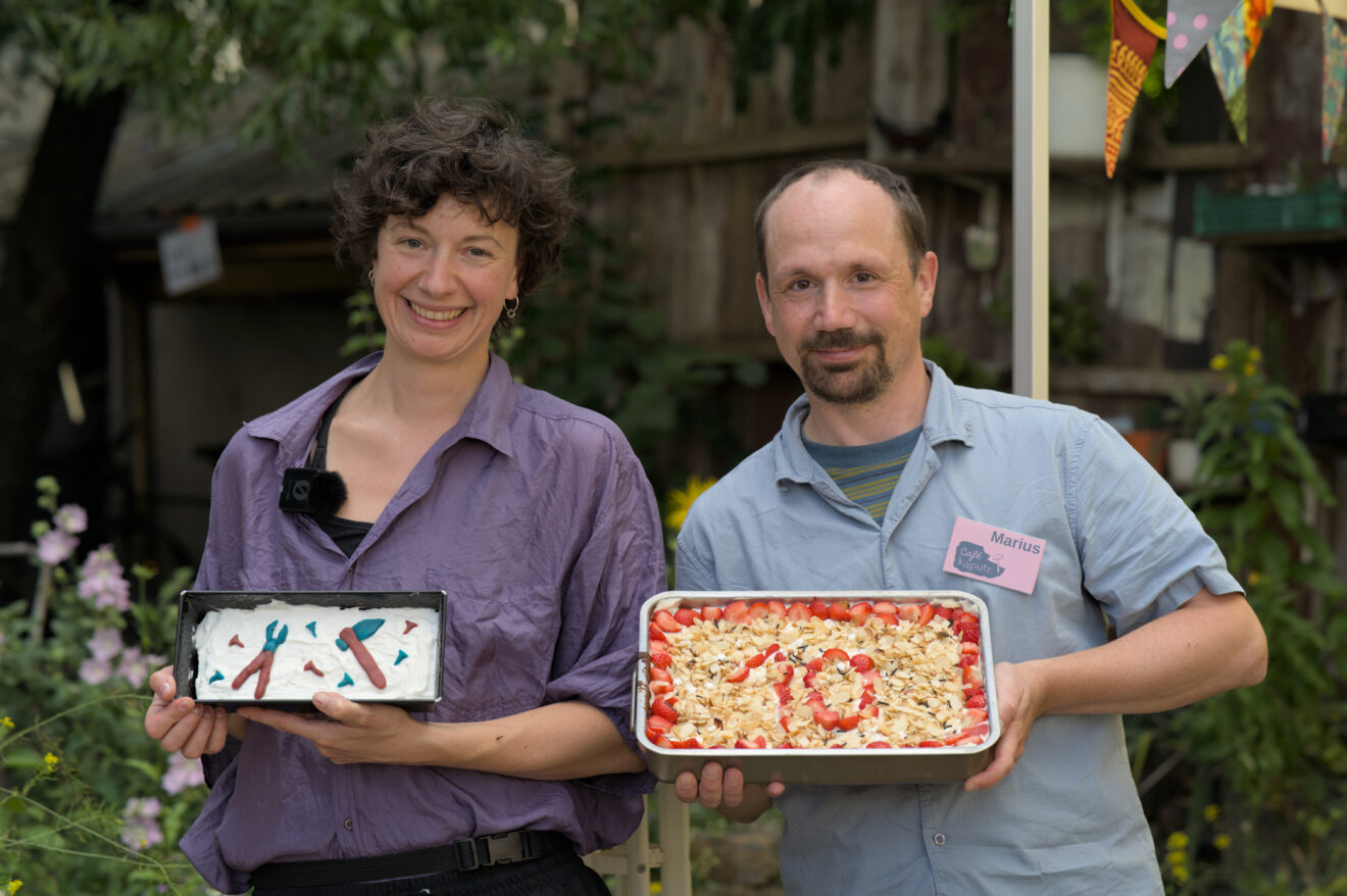 Auf dem Foto sind Lisi und Marius vom Organisationsteam des Café kaputt mit zwei Geburtstagskuchen fürs Café kaputt zu sehen.