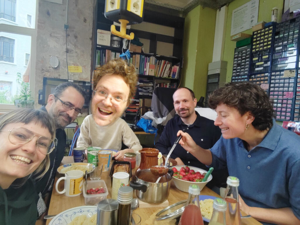 Das Café kaputt Organisationsteam am Mittagstisch mit Nudeln und Tomatensoße.