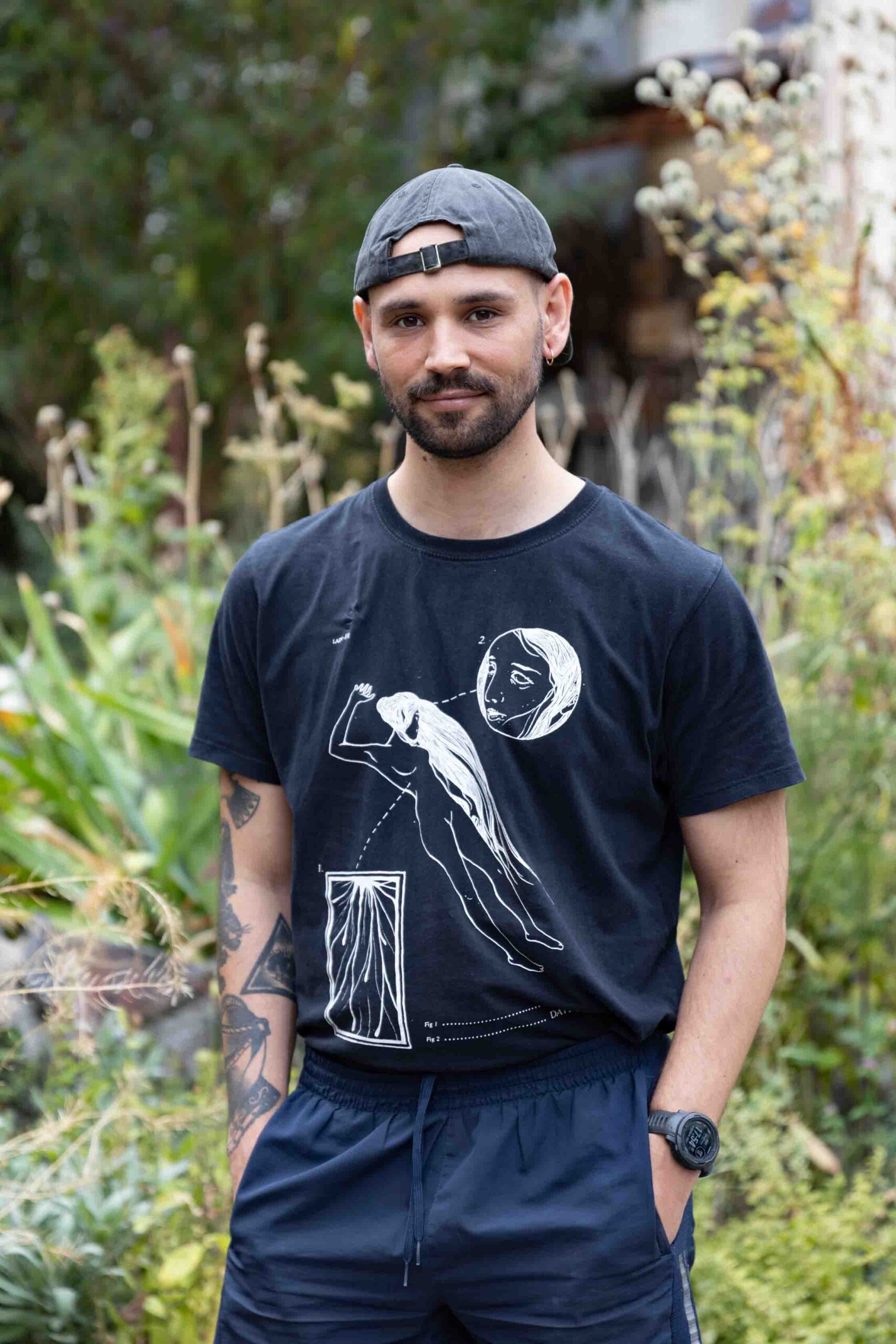 Ein Mann mit Mütze und T-Shirt im Garten